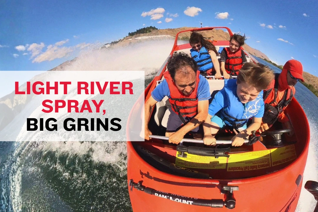 Passengers on a jet boat laughing as light spray comes over the bow