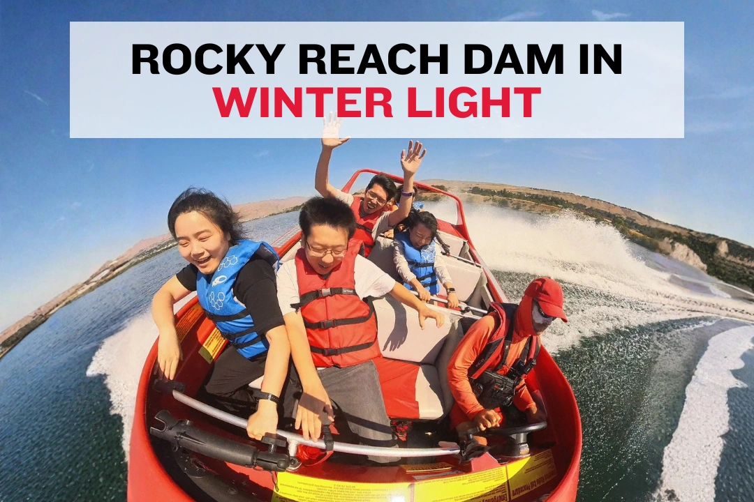 Rocky Reach Dam on the Columbia River with snow‑covered hills in the background.