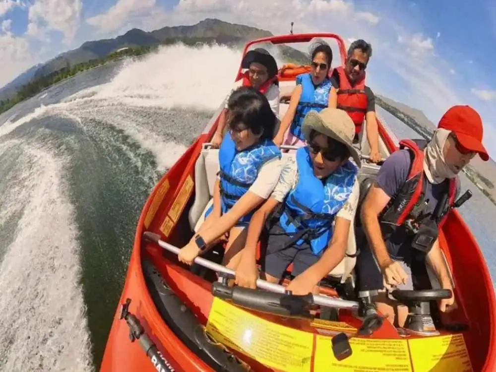 Red jet boat speeding along the Columbia River with passengers